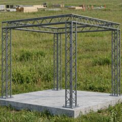 Каркас из четырех металлических колонн с верхней фермой на бетонном основании.