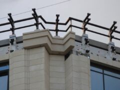 Готовый участок фасада жилого комплекса с установленным металлическим каркасом и смонтированными ограждениями