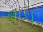 Панорама зоны кроссфита в „Андрей-Арена“: зелёные рамы на фоне синего покрытия стен крытого манежа